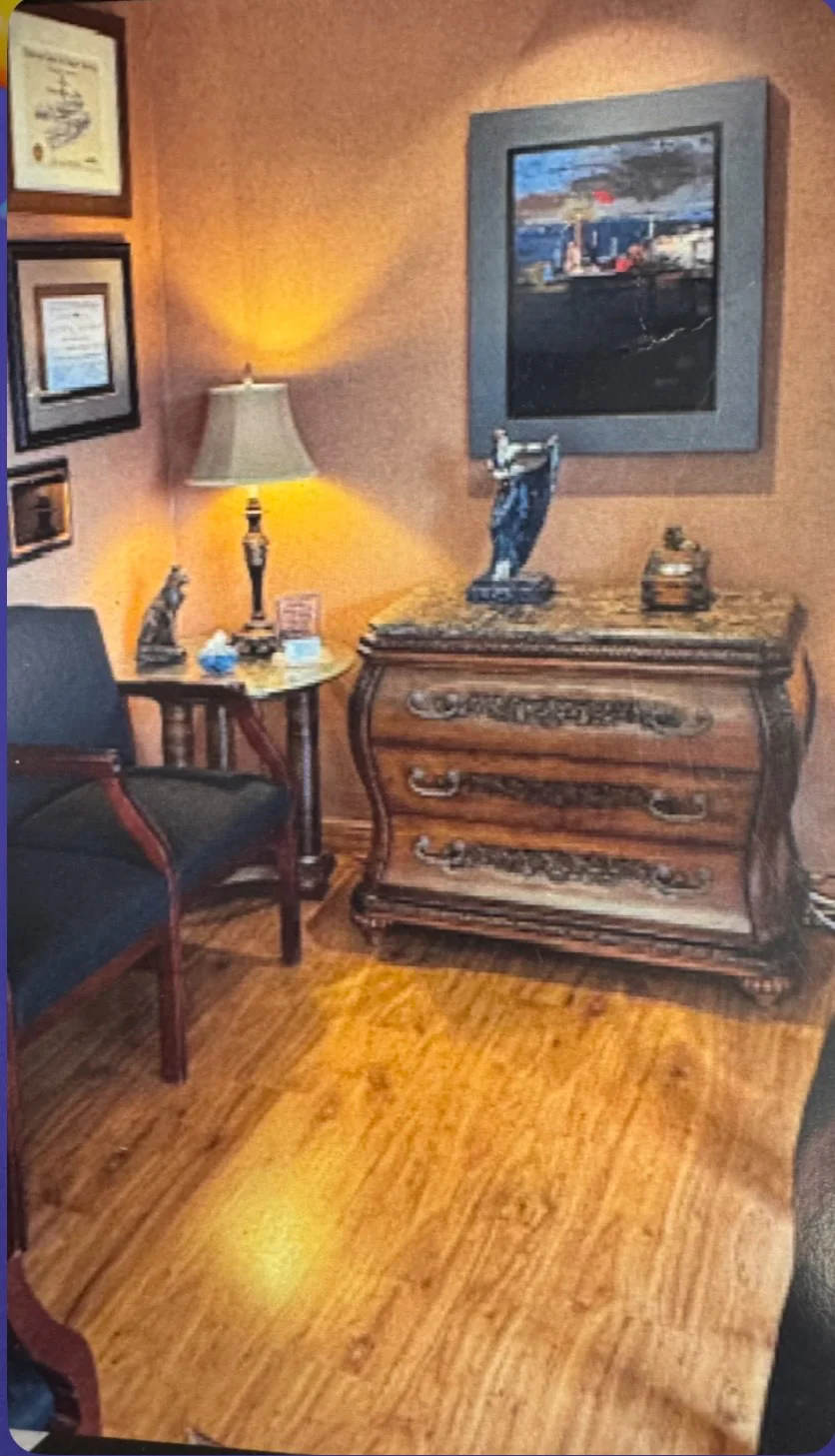 Front reception area at Calm Dental Care with antiques, warm lamp light, and framed artwork